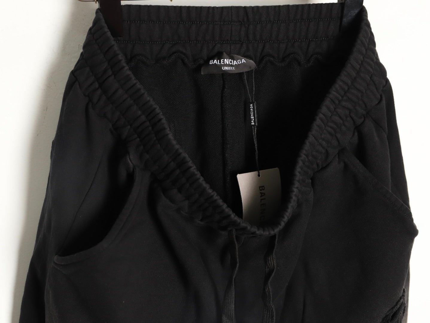 Balenciaga distressed shorts with a blurred Coca-Cola logo.