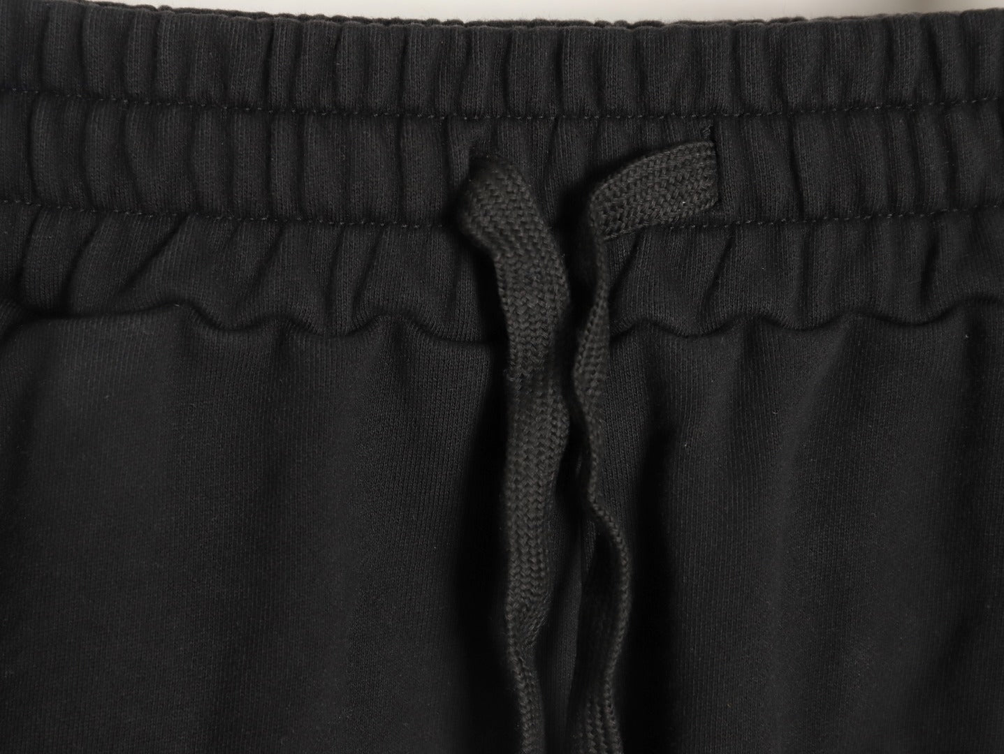 Balenciaga distressed shorts with a blurred Coca-Cola logo.