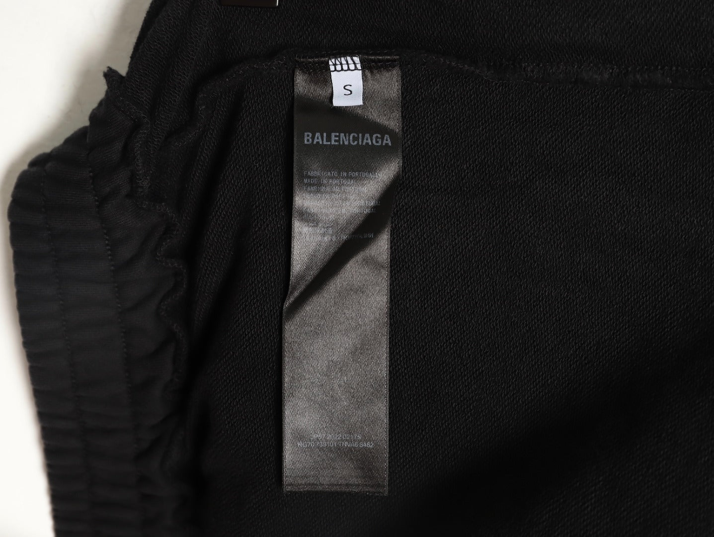 Balenciaga distressed shorts with a blurred Coca-Cola logo.