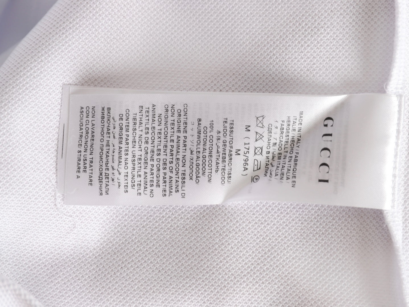 GUCCI short-sleeved polo shirt with lettering and woven ribbon at the neckline.