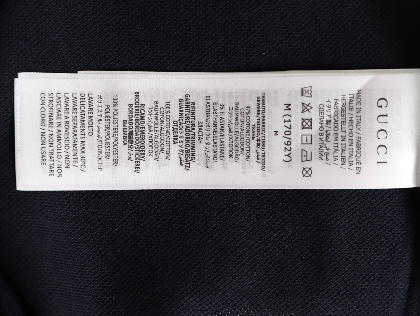 GUCCI short-sleeved polo shirt with lettering and woven ribbon at the neckline.